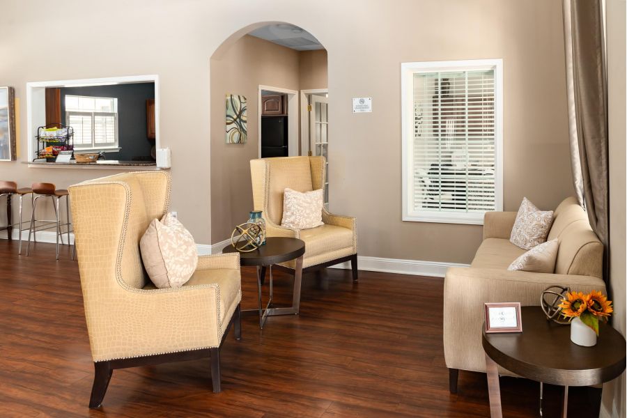Cedar Grove apartment homes with A cozy living room with two beige chairs, a sofa, side tables, and wooden flooring.