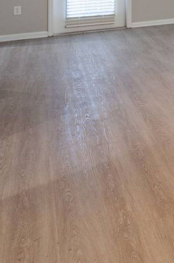 Attain on 5th apartment homes with Empty room with light wood flooring, beige walls, and a window with closed blinds letting in some light.