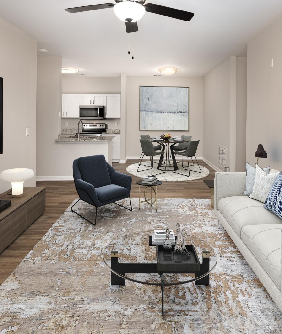 Cedar Grove apartment homes with Modern living room with a sofa, armchair, TV, and view into a small dining area and kitchen.