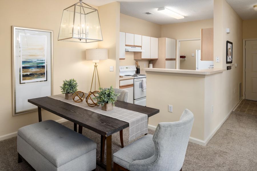 Cedar Grove apartment homes with Modern apartment kitchen and dining area with wooden table, upholstered chairs, and neutral decor.