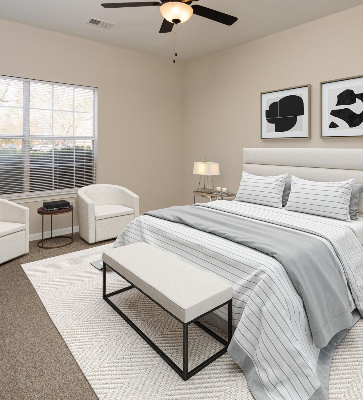 Cedar Grove apartment homes with Modern bedroom with a neatly made bed, two armchairs, large window, and minimalist decor.
